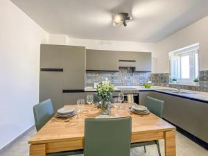 une cuisine avec une table en bois et des chaises ainsi qu'une salle à manger dans l'établissement Designer Duplex Penthouse in Floriana, à Il-Furjana