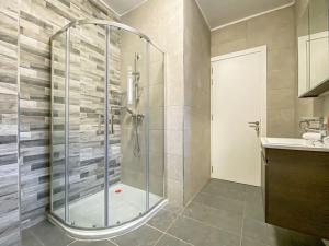 La salle de bains est pourvue d'une douche avec une porte en verre. dans l'établissement Designer Duplex Penthouse in Floriana, à Il-Furjana