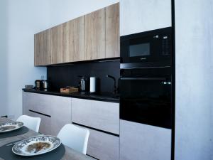 een keuken met een zwarte oven en een tafel bij Wonderful downtown apartment-HD NETFLIX, KING-SIZE BED, two minutes' walk from metro in Milaan