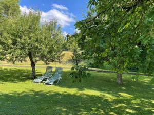 3 Stühle im Gras unter Bäumen in der Unterkunft Ferienwohnung Leixenring in Riedenburg