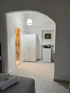 a room with a kitchen and a room with a bed at Zolfo Antico Beach Apartment Perissa in Perissa