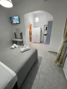 a bedroom with a bed with two towels on it at Zolfo Antico Beach Apartment Perissa in Perissa