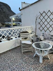a patio with a table and a chair and a table at Zolfo Antico Beach Apartment Perissa in Perissa