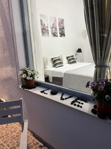 a view of a bedroom with a bed and a mirror at Zolfo Antico Beach Apartment Perissa in Perissa