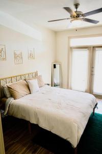 een slaapkamer met een wit bed en een plafondventilator bij Emerald City Luxury Suite ~Fully Gated Community in Midland