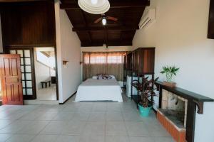 ein Schlafzimmer mit einem Bett in der Mitte eines Zimmers in der Unterkunft Pousada Casa Aratuca - 200mt da praia in São Francisco do Sul