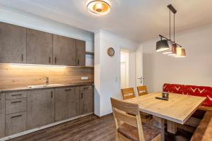 eine Küche und ein Esszimmer mit einem Holztisch in der Unterkunft Apartment mit Blick auf die Berge in Rettenstein