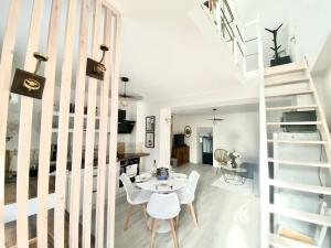 een woonkamer met een trap en een tafel en stoelen bij l'Escapade Seysselane in Seyssel