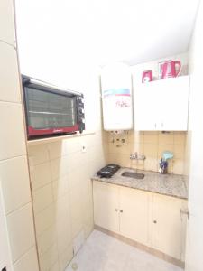 a small kitchen with a sink and a microwave at Departamento Temporario Céntrico Mendoza in Mendoza