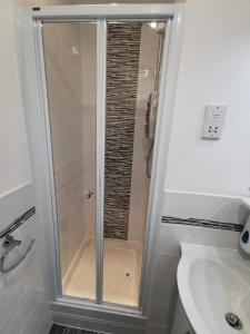 um chuveiro com uma porta de vidro na casa de banho em The Kerswell Hotel em Morecambe