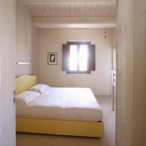 1 dormitorio con cama y ventana. en Agriturismo Pozzuolo, en Serrungarina