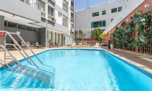 una piscina con sedie e un edificio di Tabas Lindíssimo apê 2 quartos - Leblon LB0045 a Rio de Janeiro