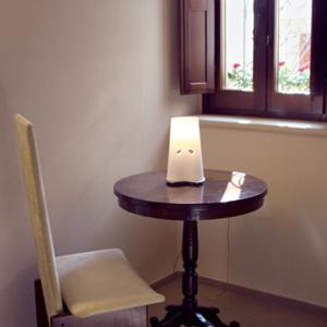 Una pequeña mesa en una habitación con una silla y una ventana en Agriturismo Pozzuolo, en Serrungarina