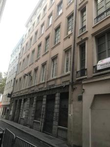 un grand bâtiment situé dans une rue en face d'un bâtiment dans l'établissement Cosy lyon Opera, à Lyon