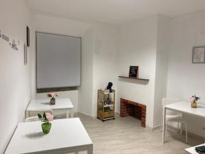 5 Senses Hostel في سيتوبال: غرفة بطاولتين وغرفة بيضاء مع موقد