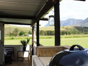 a porch with a view of a field and mountains at Arumvale Country Retreat in Swellendam