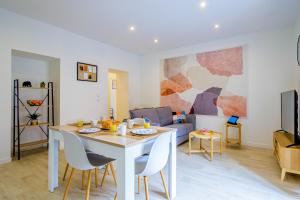 a living room with a table and chairs and a couch at Le 54-GregIMMO-Appart'Hôtel in Belfort