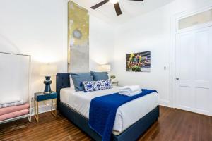 a bedroom with a bed with a blue and white comforter at Luxury 4BR in Uptown NOLA in New Orleans