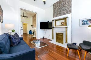 a living room with a blue couch and a fireplace at Luxury 4BR in Uptown NOLA in New Orleans