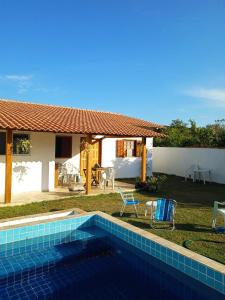 a swimming pool in front of a house at Pousada Grão de Areia in Búzios