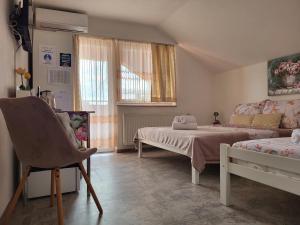 ein Schlafzimmer mit einem Bett und einer Couch und einem Fenster in der Unterkunft Rooms Sapina in Korenica