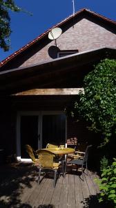 eine Terrasse mit einem Tisch und Stühlen auf einer Terrasse in der Unterkunft Ferienhaus im urigen Garten bzw Eulenhaus in Zingst