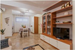ein Wohnzimmer mit einem TV und einem Esszimmer in der Unterkunft Trilocale a 150 metri Spiaggia Alghero in Alghero