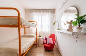 1 Schlafzimmer mit 2 Etagenbetten und einem roten Stuhl in der Unterkunft Trilocale a 150 metri Spiaggia Alghero in Alghero