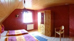 a bedroom with a bed and a window and a chair at Eule ost und west Ferienhaus im urigen Garten in Zingst