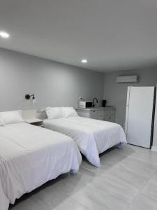 een slaapkamer met 2 bedden en een witte muur bij White Sands Inn, Marina, Bar & Grill in Port Isabel