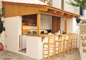 an outdoor kitchen with a bar with stools at Marina Hotel in Agios Kirykos