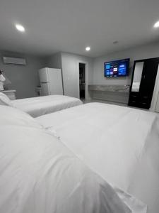 een kamer met 2 bedden en een tv aan de muur bij White Sands Inn, Marina, Bar & Grill in Port Isabel