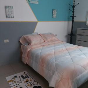 1 dormitorio con cama con sábanas rosas y alfombra en Departamento en Cajamarca, en Cajamarca