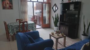 sala de estar con sofá azul y TV en Departamento en Cajamarca en Cajamarca