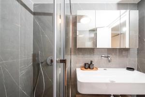a bathroom with a sink and a shower with a mirror at Serene seafront villas in Nea Iraklia