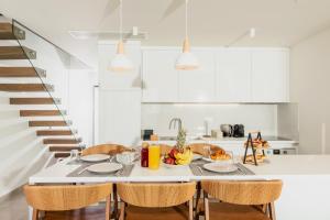 a white kitchen with a table and chairs at Serene seafront villas in Nea Iraklia