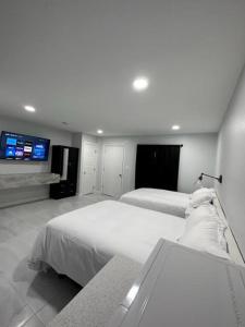 1 dormitorio con 2 camas y TV de pantalla plana en White Sands Inn, Marina, Bar & Grill, en Port Isabel