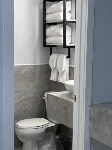 a bathroom with a toilet and a shelf with towels at White Sands Inn, Marina, Bar & Grill in Port Isabel
