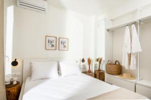 a white bedroom with a bed and white walls at Serene seafront villas in Nea Iraklia