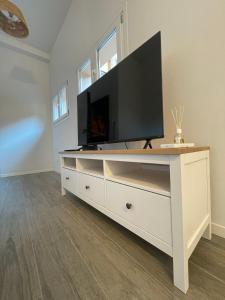 un centro de entretenimiento blanco con TV de pantalla plana. en NORD MILANO LUXURY APARTMENTS, en Bresso