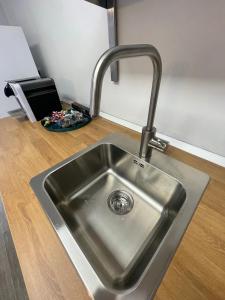 a kitchen sink with a faucet on a wooden floor at NORD MILANO LUXURY APARTMENTS in Bresso