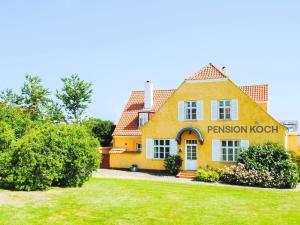 a yellow house with a sign on the front of it at Holiday home Gudhjem XLVI in Gudhjem