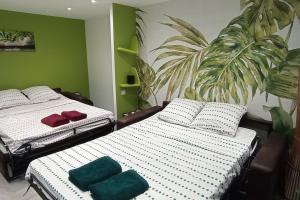2 camas en una habitación con verde y blanco en F1 idéalement situé en RDC, en Raon-lʼÉtape
