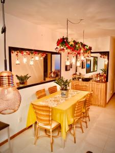 ein Esszimmer mit einem gelben Tisch und Stühlen in der Unterkunft Home Club encantador. Beto Carrero in Penha