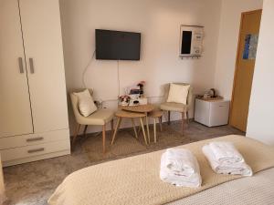 a room with a bed and two chairs and a tv at Rooms Sapina in Korenica
