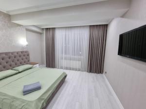 キシナウにあるComfortable Luxury Apartments in Centerのベッドと薄型テレビのある寝室