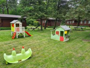 einen Hof mit zwei Spielstrukturen und einem Spielplatz in der Unterkunft Ośrodek Wypoczynkowy Amber in Kąty Rybackie