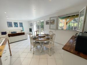 een keuken en een woonkamer met een tafel en stoelen bij Appartement au calme avec terrasse verdoyante entre Annecy et Genève in Villy-le-Pelloux