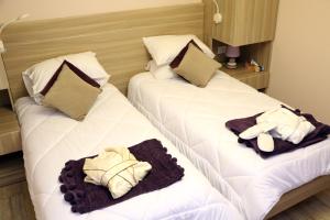 Dos camas en una habitación de hotel con toallas. en HOtello guest suites, en Jounieh
