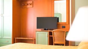 a bedroom with a television on a desk with a chair at Apulia Hotel Corigliano Calabro in Corigliano Calabro